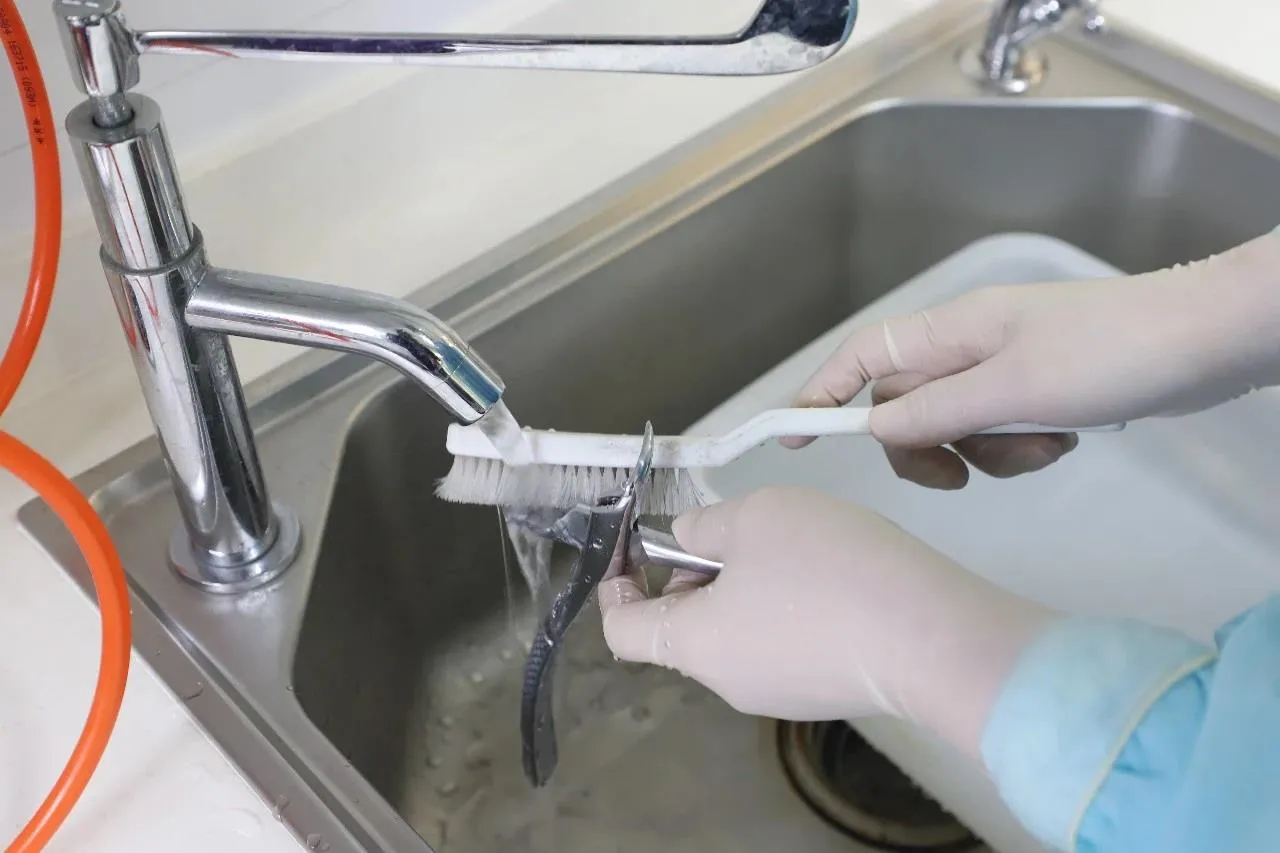 Manual cleaning of dental instruments at Nijanand Dental Clinic Jamnagar